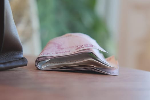 A closeup view of a stack of currency notes held together with a rubber band to stay organized