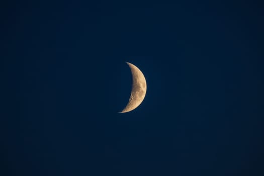 First quarter moon against a starless sky in the blue hour in Germany