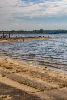 Small bay behind small local harbor at the coast of big lake next to water dame and road