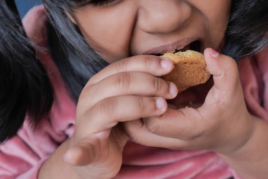 close up of child eating sweet cookies .
