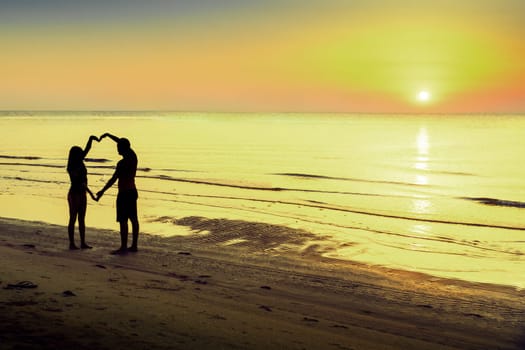 Couple in love takes a selfie against the backdrop of the morning dawn on the sea.