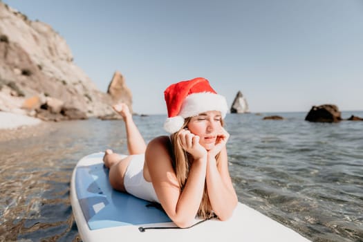 Close up shot of happy young caucasian woman looking at camera and smiling. Cute woman portrait in bikini posing on a volcanic rock high above the sea