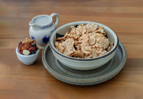 Homemade Gadola, Cereal and Nuts in Ceramic bowl served with Almond milk on wooden table. Healthy breakfast. Space for text, Selective focus.