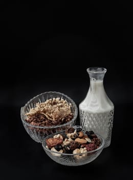Tasty Gadola, Cereal and Nuts in Glass Bowl served with Almond Milk with Dark Background. Healthy Breakfast, Copy space, Selective focus.