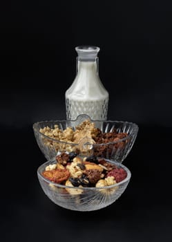 Homemade Gadola, Cereal and Nuts in Glass Bowl served with Almond Milk in Black Background. Healthy Breakfast, Space for text, Selective focus.
