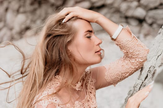 Woman travel sea. Young Happy woman in a long red dress posing on a beach near the sea on background of volcanic rocks, like in Iceland, sharing travel adventure journey