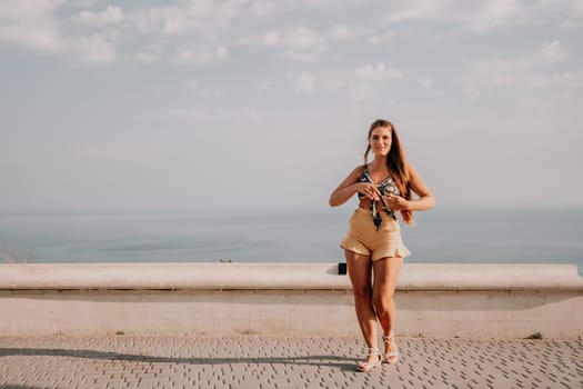 silhouette of a happy woman who dances, spins and raises her hands to the sky. A woman is enjoying a beautiful summer day.