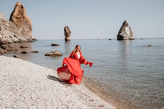 Woman travel sea. Happy tourist taking picture outdoors for memories. Woman traveler looks at the edge of the cliff on the sea bay of mountains, sharing travel adventure journey.