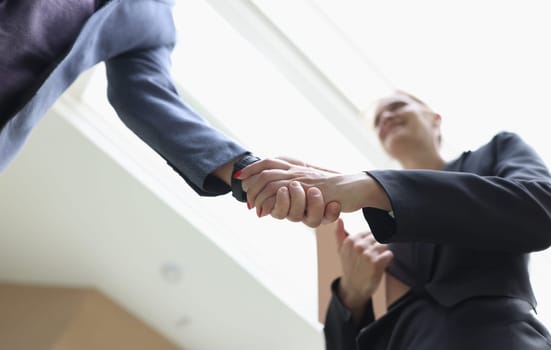 Businessman and woman shaking hands in office closeup. Welcome acquaintance greeting or gratitude gesture concept
