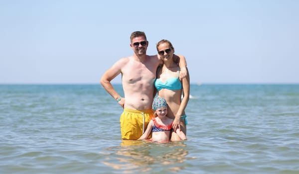 Happy family have fun on beautiful warm sunny beach in sea. Joyful family trips on summer to sea