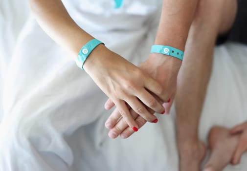 Male female hands holding hands with bracelets. Husband and wife or love couple together and hold each other hands