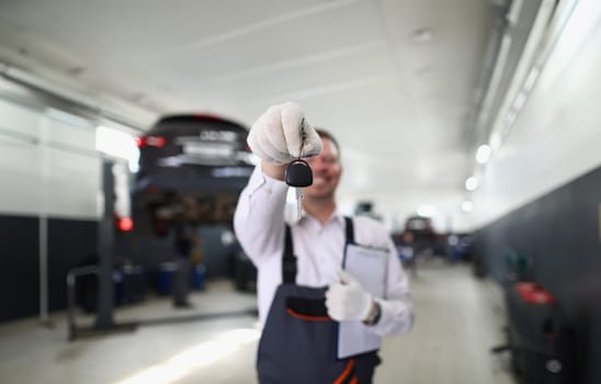 Auto mechanic holds clipboard and car keys. Quality auto repair services