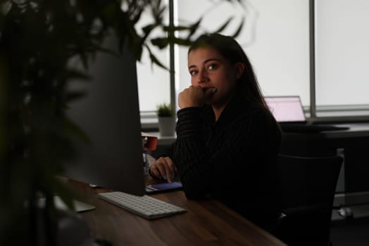 Portrait of tired pensive manager in dark office workplace. Businesswoman working late at headquarters