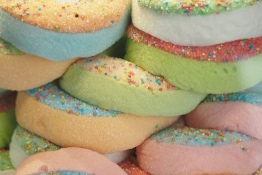 A colorful stack of marshmallow treats topped with vibrant sprinkles, making them festive