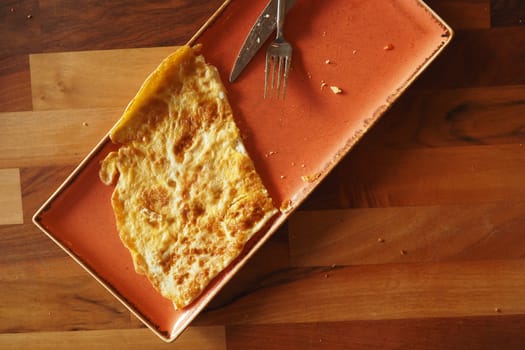 A delicious and perfectly cooked golden omelette served beautifully on a rustic plate