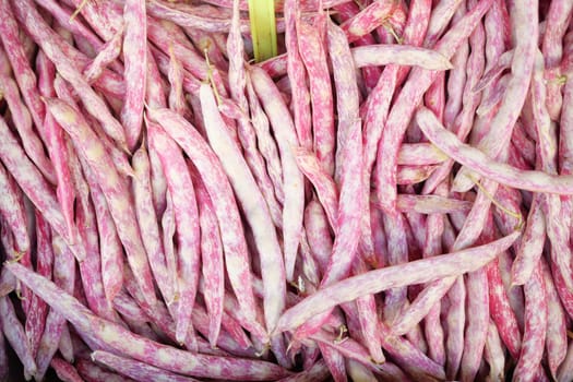 At a farmers market, vibrant purplestriped green beans stand out among fresh produce