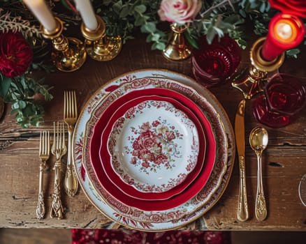 Festive table setting with candles and arrangement of beautiful red flowers. Holiday concept. High quality photo