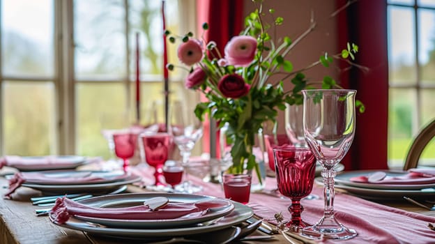 Festive table setting with candles and arrangement of beautiful red flowers. Holiday concept. High quality photo