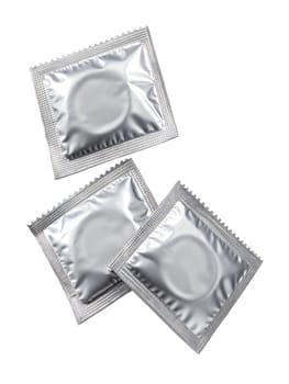 Three silver packages of condoms isolated on white background