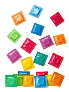 Lots of colorful condoms levitating in the air isolated on white background, top view.