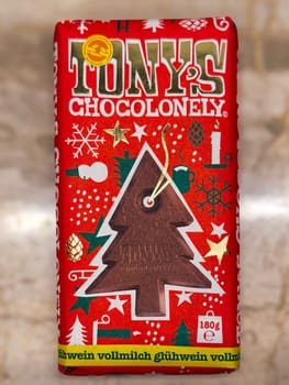 Thessaloniki, Greece - December 12 2024: Tony’s Chocolonely Festive Chocolate Bar with Holiday Decoration Featuring Christmas Tree Design.