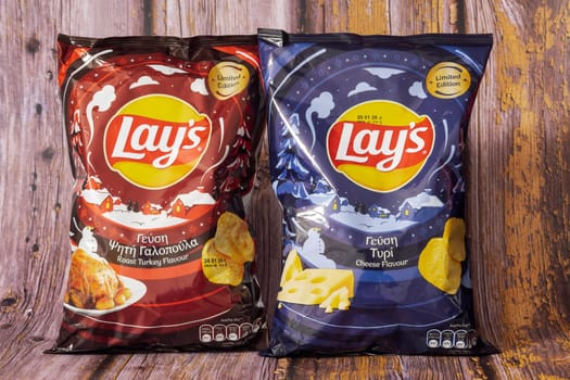 Thessaloniki, Greece - November 23 2024: Two Lay's chips bags with limited edition seasonal flavors, Roast Turkey and Cheese, photographed against a wooden rustic background.