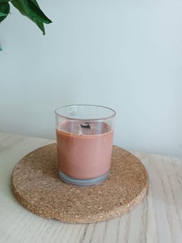 Handmade soy organic eco brown candle with wooden stick staying on the wooden table. High quality photo. Morning routine. Morning rituals. Meditations