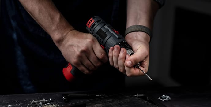 Man Holds Drill In Hands Close-Up