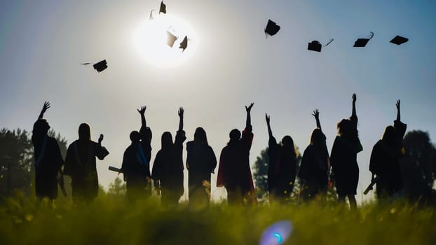 Silhouetted graduates joyfully tossing their caps into the air against a vibrant sunset, celebrating a significant milestone in their academic journey
