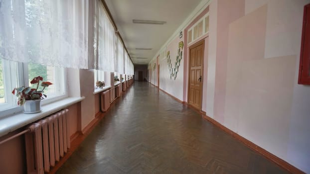 Empty school corridor with sunlight shining through windows, creating a nostalgic atmosphere on the last school day