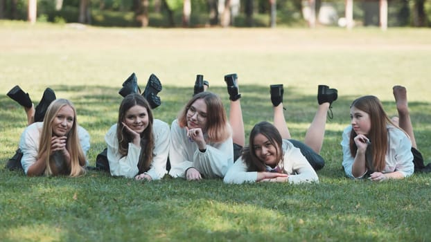Group of high school students lying on grass in a park, enjoying their free time after school