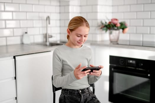 Cute Little Girl Playing An Online Game On A Smartphone At Home