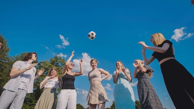 Friends tossing a ball in a meadow on a summer day