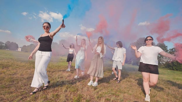 Group of joyful high school students celebrating summer with colorful smoke bombs, enjoying freedom and friendship in a sunny field