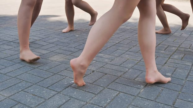 Ballet dancers joyfully walk barefoot on pavement after school, embracing freedom and camaraderie, marking the end of training with optimism for their future careers