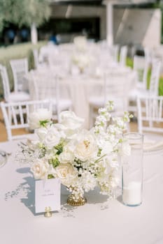 Name plate on a stand near a bouquet of flowers on a festive table. High quality photo