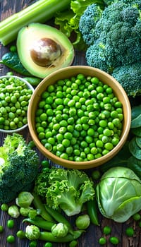 A bowl of fresh green peas, snap peas, and other leafy green vegetables displayed on a wooden table. These natural foods make a perfect plantbased ingredient for any cuisine recipe