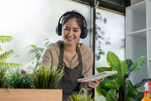 A young woman happily tends to her indoor garden, surrounded by vibrant plants and natural light, showcasing a love for nature and home gardening.