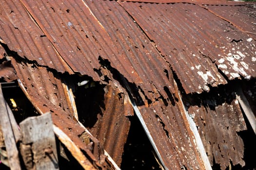 Background of scratches and holes in a rusty zinc roof.