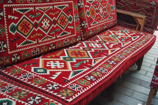 A vibrant red sofa with intricate geometric patterns, enhancing any space elegantly