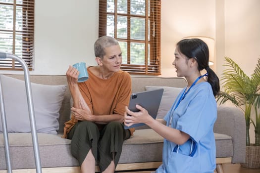 A young nurse offers health care advice to an elderly woman, fostering a supportive and caring environment in a cozy living room.
