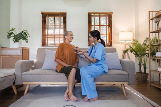 A young nurse offers health care advice to an elderly woman, fostering a supportive and caring environment.
