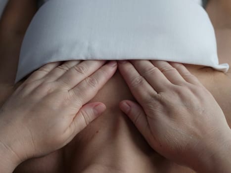 The masseur massages the client in the thoracic area of the collarbone, breast. Close-up, no face