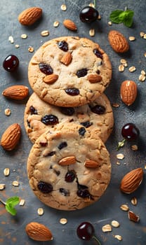 Three almond and cherry cookies are stacked on a table, showcasing a delicious combination of fruit and nuts in a delightful baked good