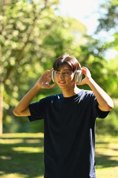 Portrait of male runner taking a break and listening music on headphones.