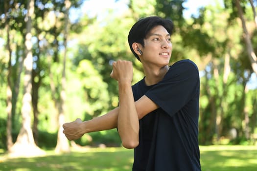 Man runner stretching in the park on a sunny day. Heath and fitness concept.