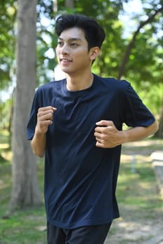Young asian man enjoying a morning run in nature. Wellness and Healthy lifestyle concept.