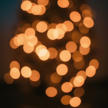 Soft, blurred bokeh lights in warm tones create a festive, cozy atmosphere, perfect for holiday and celebratory moments.