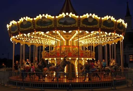 A magical nighttime scene featuring a vintage carousel illuminated by twinkling lights, creating a whimsical and festive atmosphere.
