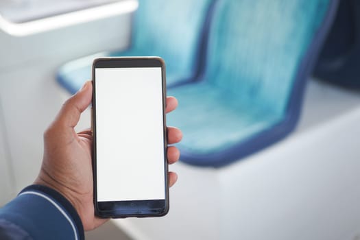 young man hand using smart phone with green screen inside of metro train ,